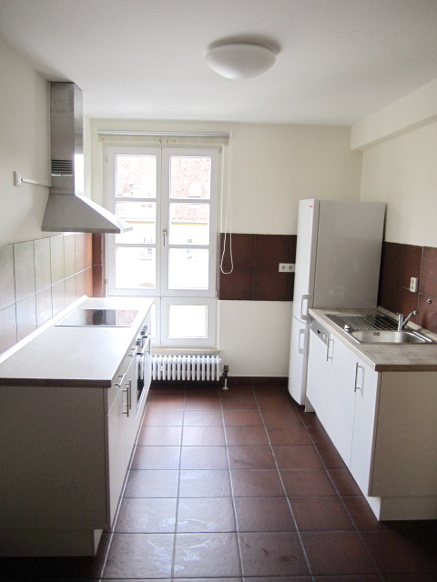 Küche mit Kühlschrank, Kochfeld und Heizkörper am Fenster – Studentenwohnheim Eichenforst Amberg